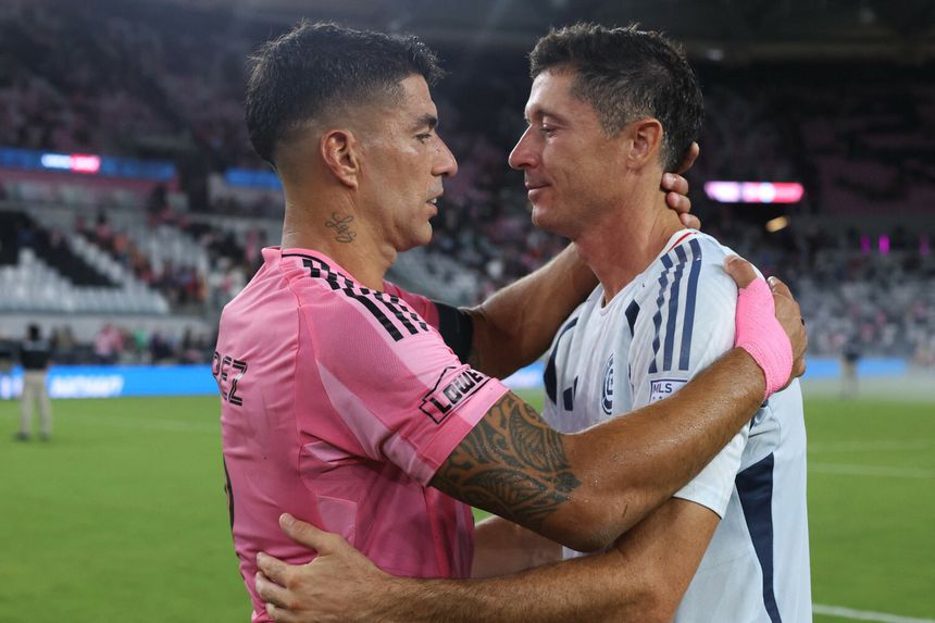 Luis Suarez i Robert Lewandowski w uścisku na boisku po meczu, emocje i serdeczność w geście.