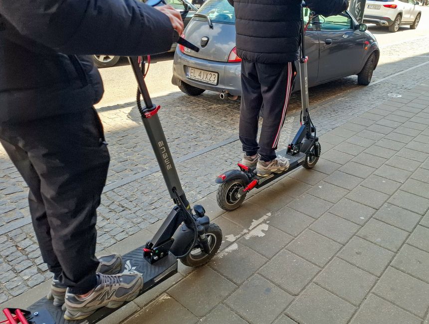 Jazda chulajnoga elektryczna po chodniku.