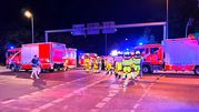 Sytuacja nocna, w której straż pożarna i ratownicy interweniują na drodze.
