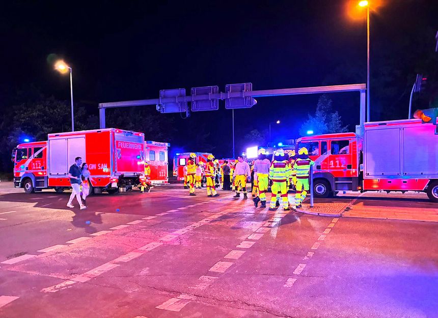 Sytuacja nocna, w której straż pożarna i ratownicy interweniują na drodze.