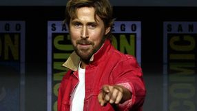 Mężczyzna w czerwonej kurtce wskazuje palcem, uśmiechając się do kamery. Tło z logo Comic-Con.