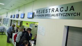 Rejestracja w poradni specjalistycznej, widoczni pacjenci przy oknie rejestracyjnym.