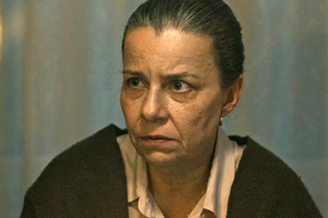 Zdjęcie zbliżenia na kobietę z wyrazem zmartwienia, z włosami spiętymi w kok.