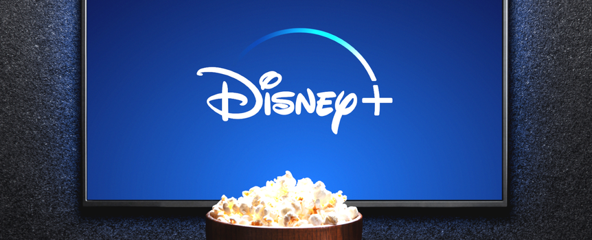 Ekran telewizora z logo Disney+ oraz miską popcornu na stole.