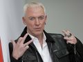 H.P. Baxxter w skórzanej kurtce z blond włosami, pokazujący dwa palce w geście.
