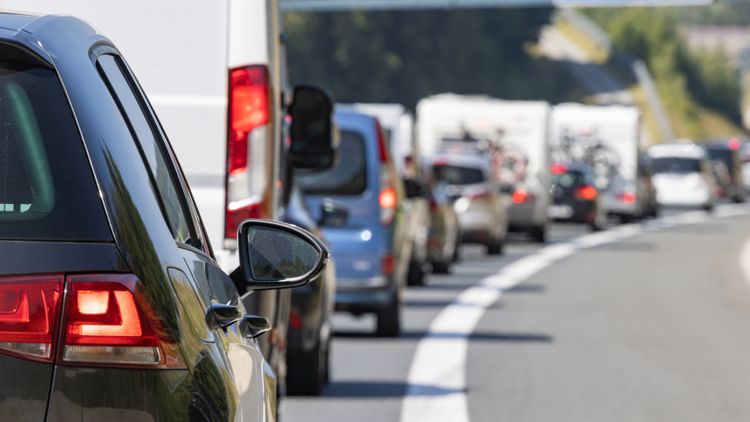 Zator drogowy z dużą liczbą samochodów na trasie, widok z tyłu pojazdu.