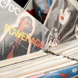 Kolekcja winyli z okładkami zespołów rockowych, m.in. AC/DC i Kiss, na stoisku.