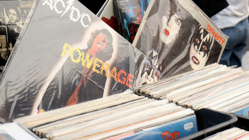 Kolekcja winyli z okładkami zespołów rockowych, m.in. AC/DC i Kiss, na stoisku.