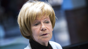 Maria Czubaszek z krótkimi, blond włosami, ubrana w szary żakiet, patrzy w kamerę.