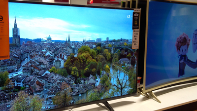 Dwa telewizory na ekspozycji: jeden z panoramą miasta, drugi z postaciami animowanymi.
