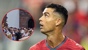 Na zdjęciu widoczny Cristiano Ronaldo w czerwonym stroju, spoglądający w górę, otoczony tłumem.