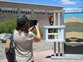 Osoba wykonująca zdjęcie przed centrum odwiedzających Furnace Creek. Temperatura wynosi 123°F (50°C).