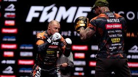 Dwóch zawodników FAME MMA w strojach sportowych, przygotowujących się do walki na tle reklam.