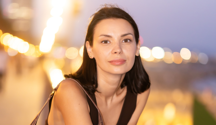 Uśmiechnięta brunetka na nadmorskim deptaku wieczorem