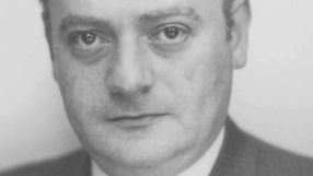 Nie rozpoznaję osoby na zdjęciu. Opis ALT: Zbliżenie na twarz mężczyzny w garniturze, z poważnym wyrazem twarzy.