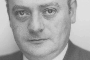 Nie rozpoznaję osoby na zdjęciu. Opis ALT: Zbliżenie na twarz mężczyzny w garniturze, z poważnym wyrazem twarzy.