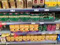 Półka w sklepie z różnymi markami kawy, w tym Jacobs i Eduscho, z cenami na metkach.