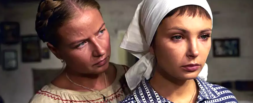 Dwie kobiety w tradycyjnych strojach, jedna z warkoczem, druga z chustą na głowie.