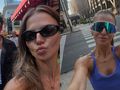 Anna Lewandowska robi selfie w mieście, w tle budynki i przechodnie.