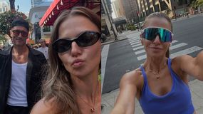 Anna Lewandowska robi selfie w mieście, w tle budynki i przechodnie.