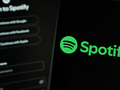 Logo aplikacji Spotify na czarnym tle z opcjami logowania przez różne platformy.