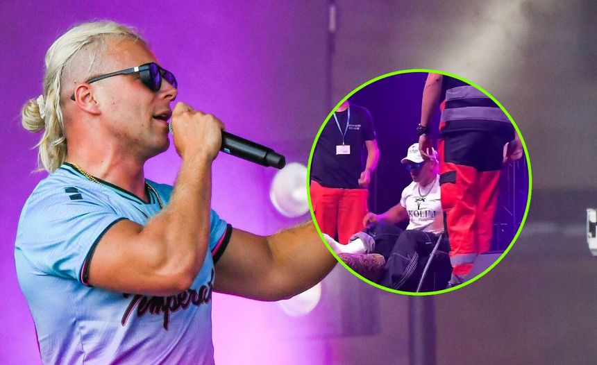Skolim w sportowej koszulce śpiewa na scenie, obok medycy pomagają mu wejść na scenę..