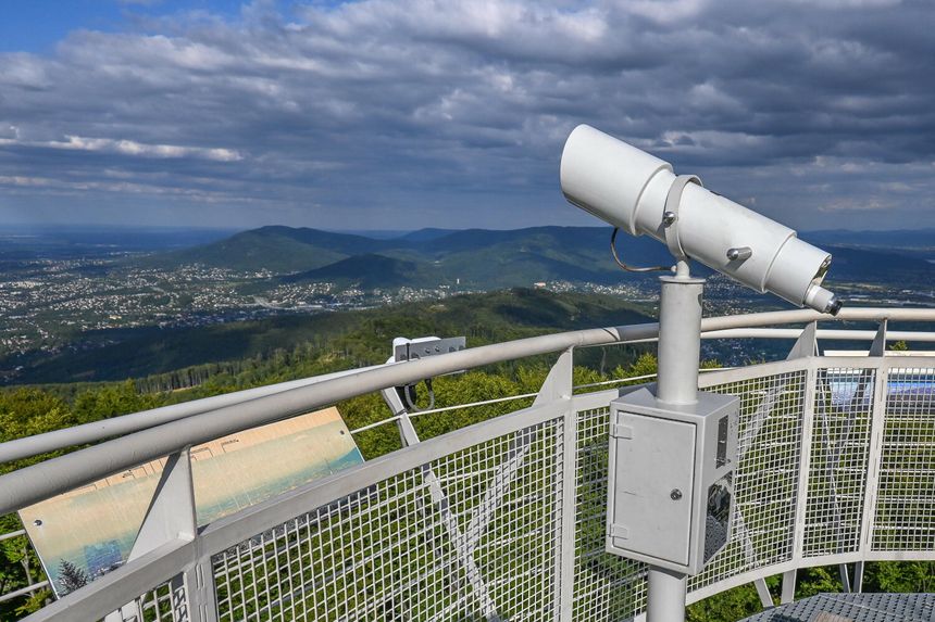 Widok z tarasu widokowego, teleskop skierowany na góry w tle oraz panoramiczny krajobraz.
