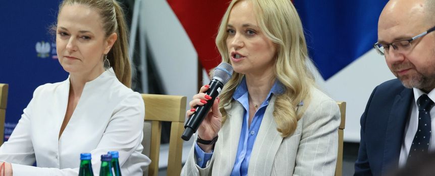 Na zdjęciu trzej uczestnicy spotkania. Kobieta z mikrofonem, po lewej w białej bluzce.