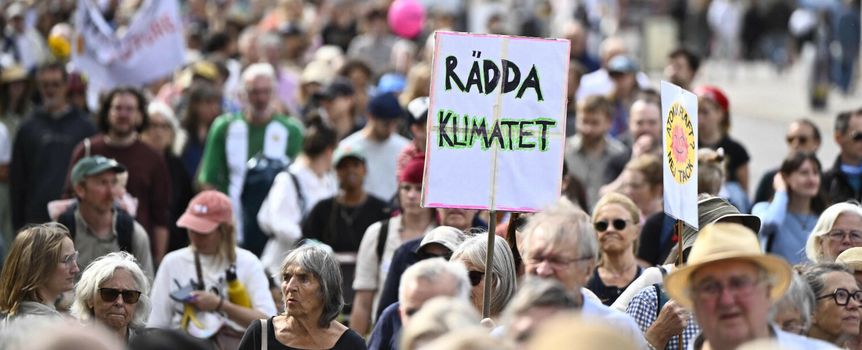 Tłum protestujących z transparentem 