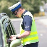 Policjant wręcza mandat - materiał prasowy