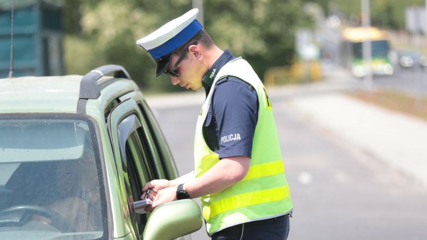 Policjant wręcza mandat - materiał prasowy