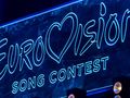 Logo konkursu Eurowizji w jasnych neonowych barwach na ciemnym tle.