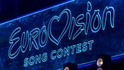 Logo konkursu Eurowizji w jasnych neonowych barwach na ciemnym tle.