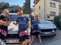 Skolim i Luxon stoją przed luksusowym samochodem na ulicy.
