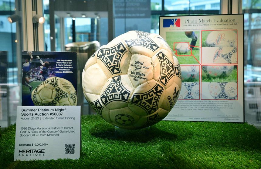 Piłka nożna z mundialu 1986, eksponowana na trawie, wraz z dokumentacją i opisem.