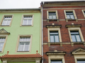 Dwie kamienice stojące obok siebie - zielona i z cegły
