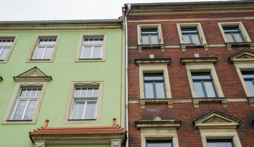 Dwie kamienice stojące obok siebie - zielona i z cegły