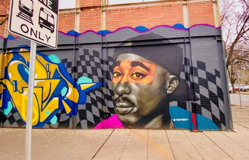 Murals przedstawiający mężczyznę z nakryciem głowy i jasnymi, intensywnymi oczami.
