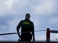 Na zdjęciu widoczny jest funkcjonariusz policji z tyłu, w czarnym mundurze.
