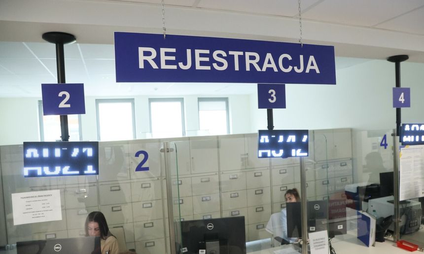 Zarejestrowane stanowiska obsługi w jasnym pomieszczeniu. Napisy informacyjne o numerach.