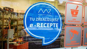 Na szybie apteki widoczny niebieski znak z napisem 