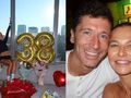 Anna Lewandowska siedzi w pomieszczeniu z widokiem na miasto, obok balony „38” i bukiety kwiatów.