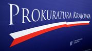 Logo Prokuratury Krajowej na granatowym tle z biało-czerwonymi akcentami.