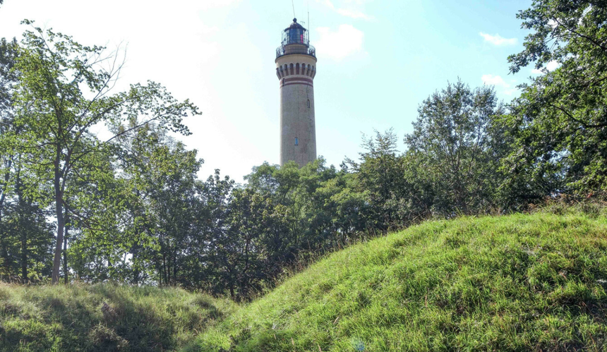 Latarnia morska w Świnoujściu otoczona zielonymi drzewami