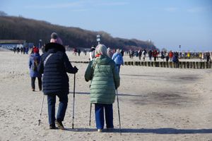 seniorzy spacerują po plaży