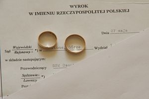 Dwie obrączki na tle dokumentu sądowego z napisem 