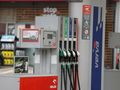 Stacja paliw z dystrybutorami. W tle reklama napoju energetycznego i informacja o tankowaniu.