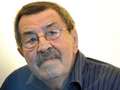Na zdjęciu widać mężczyznę z okularami, o siwych włosach i wąsach, w niebieskiej koszuli.