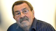 Na zdjęciu widać mężczyznę z okularami, o siwych włosach i wąsach, w niebieskiej koszuli.
