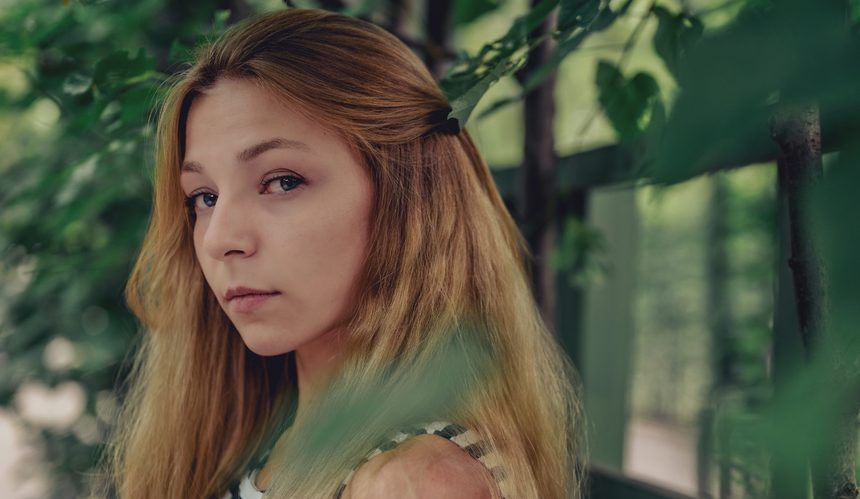 Poważna blondynka wśród zieleni